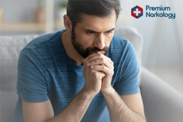 Лечение амфетамина Мужчина сидит на диване и думает